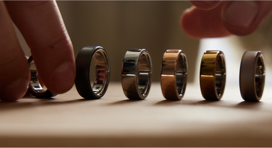 Person arranging all 6 of the brand-new Oura Ring 4 to show each Finish
