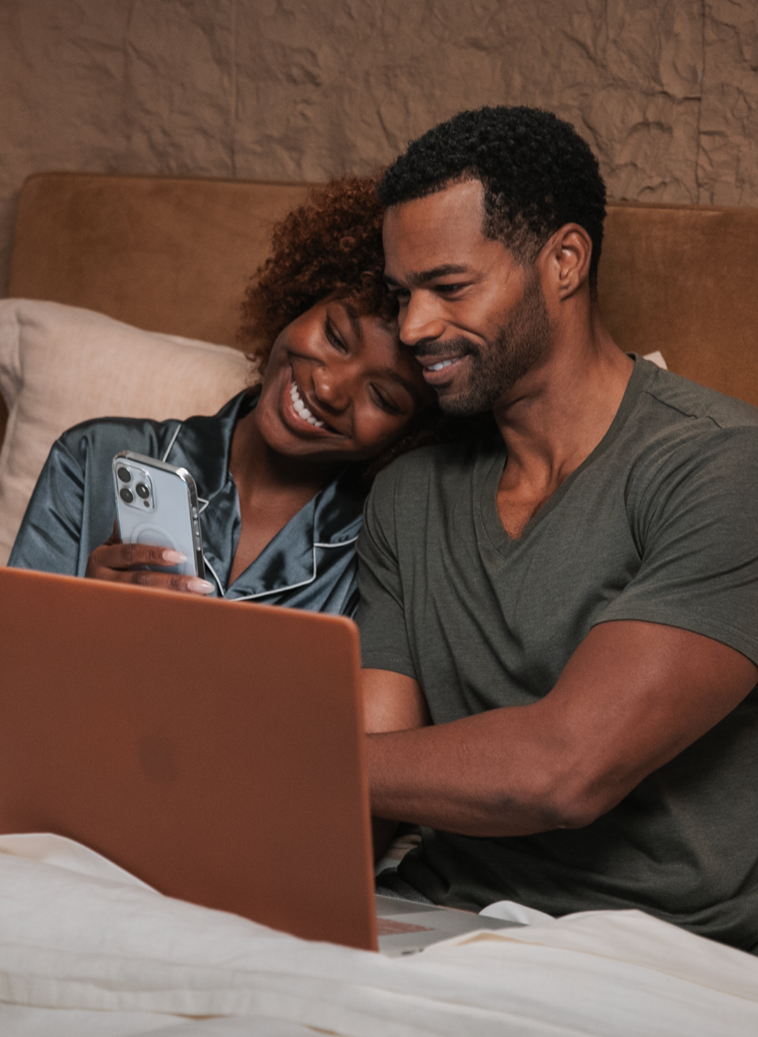Man and woman sitting in bed with laptop