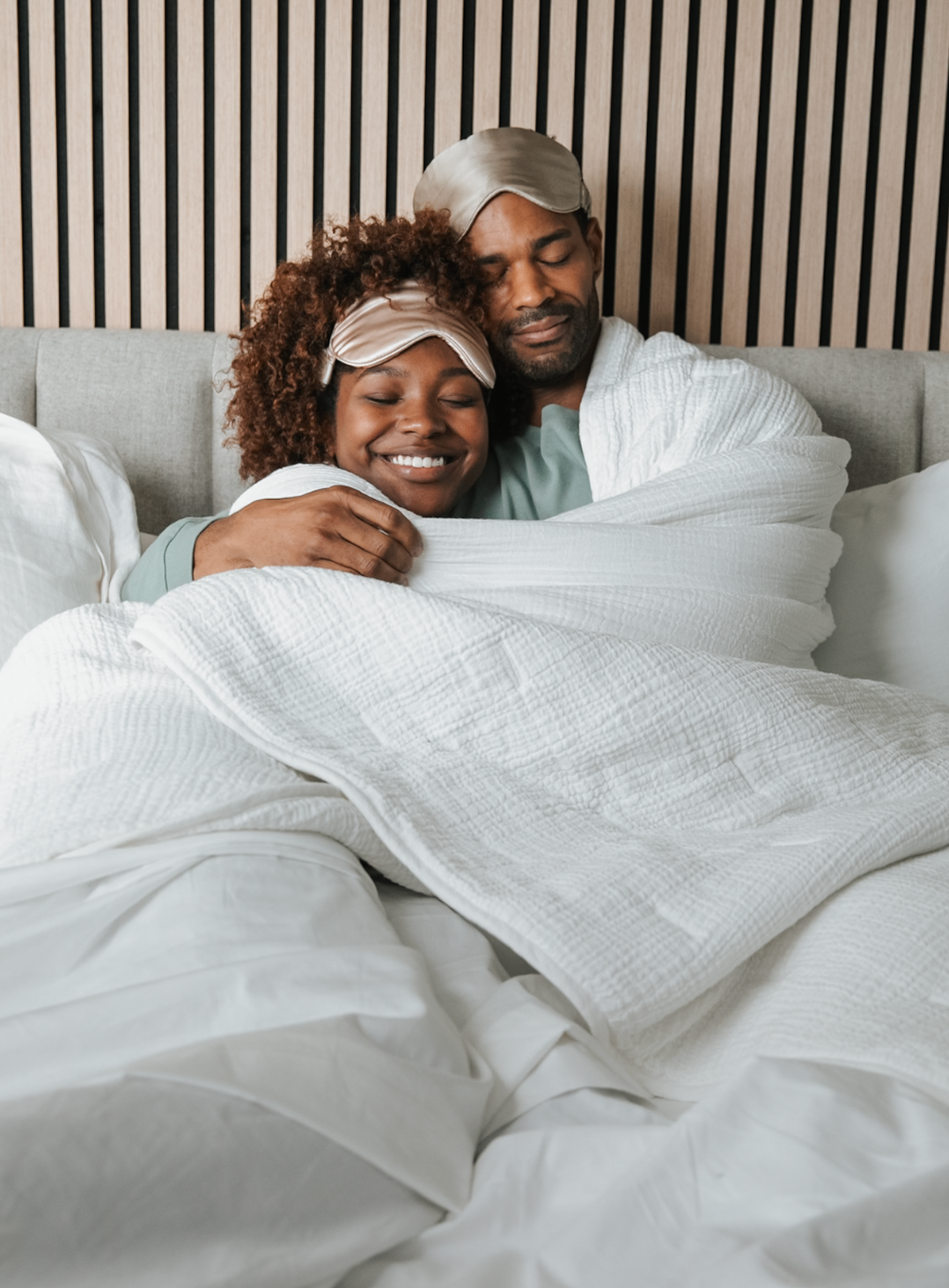 Man and woman sitting on a bed looking at a tablet