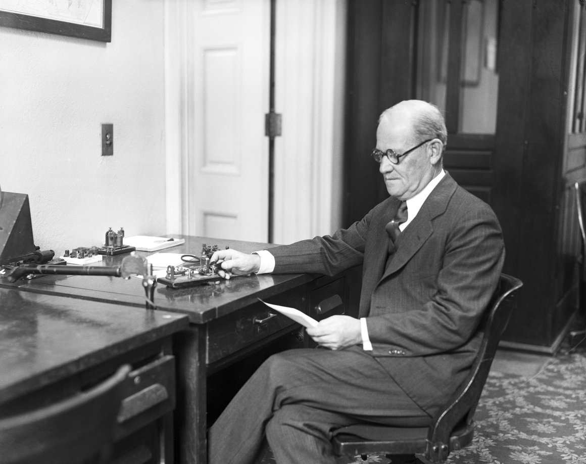 Black-and-white photo of telegraph operator Edward Smithers working at a desk in the White House in 1928.