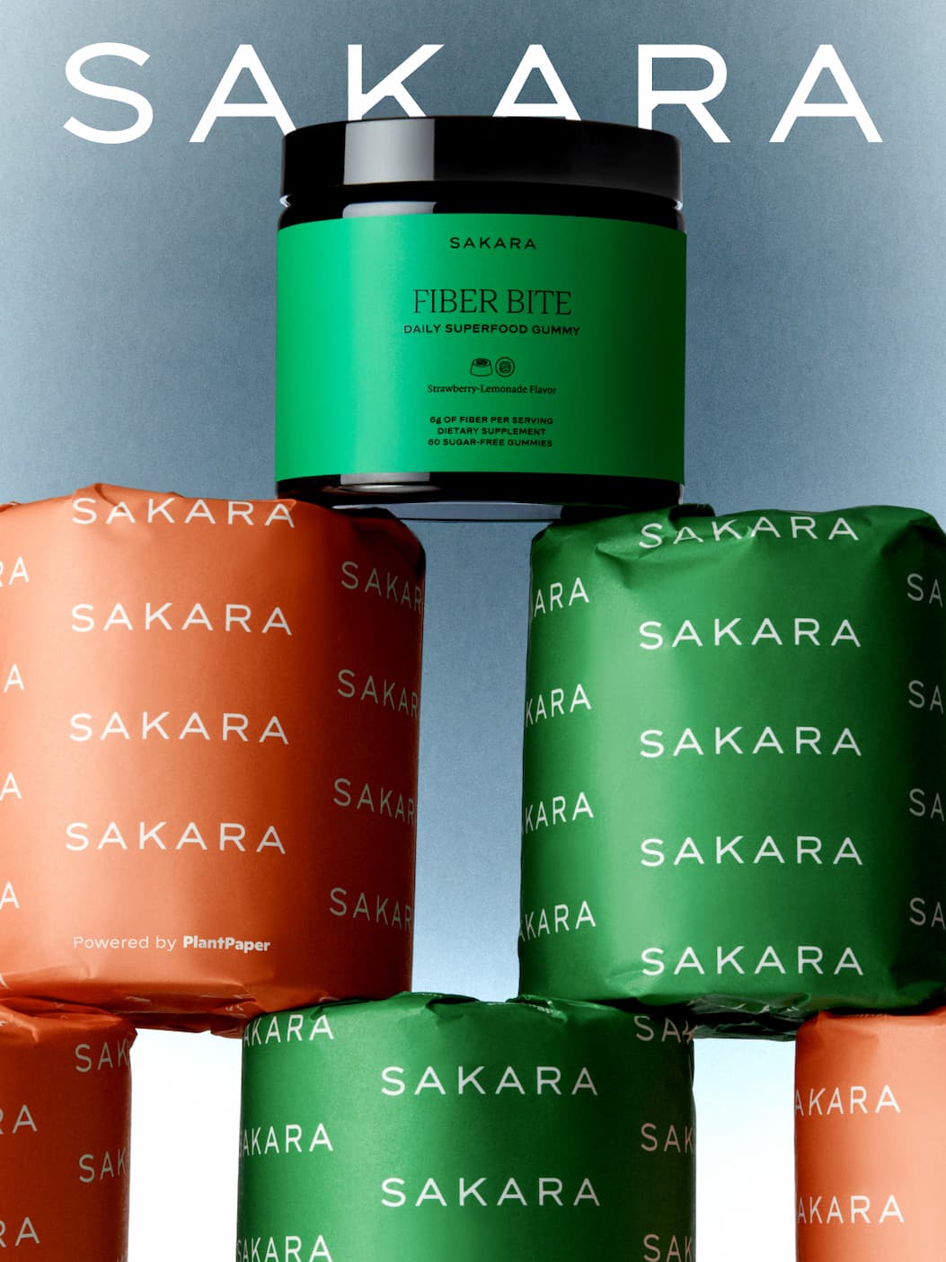 Sakara Fiber Bite jar atop a stack of orange and green Sakara toilet paper rolls