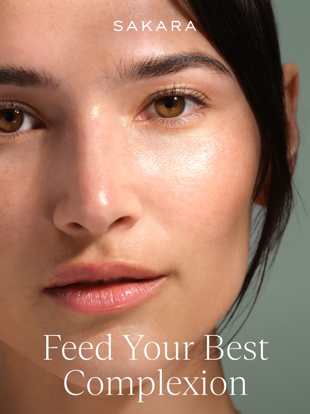 Close-up of a woman's face with glowing, radiant skin and hazel eyes against a sage green background, with the headline "Feed Your Best Complexion"
